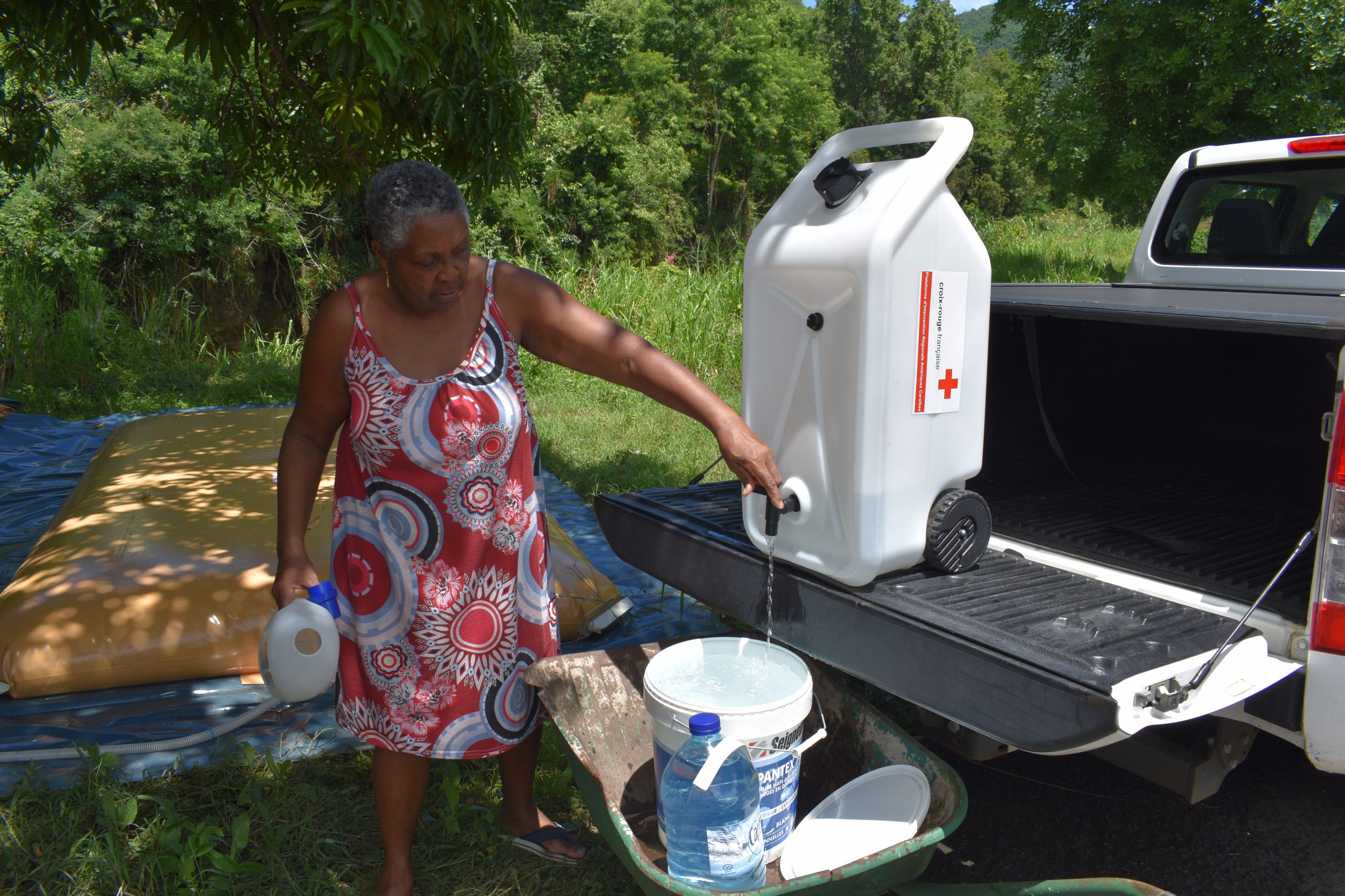 Une bénéficiaire s'approvisionne en eau à Vieux Habitants en Guadeloupe
