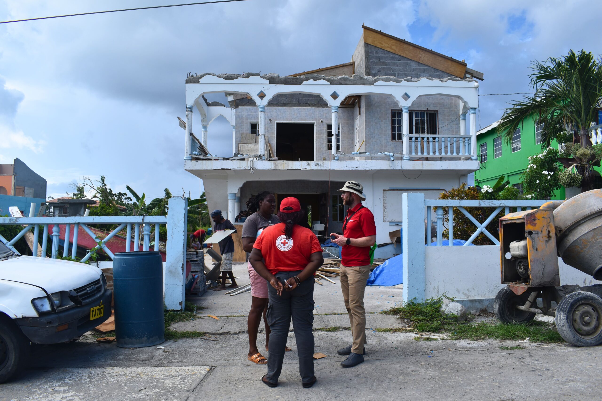 Lu-Ann McGuire, (Croix-Rouge de Grenade) et Peter Hooper (IFRC), aux côtés de la propriétaire de la maison, rénovée par Kerry et son équipe.